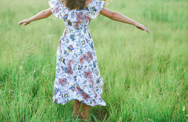 Vestido midi floral branco e azul em um gramado, à luz do dia
